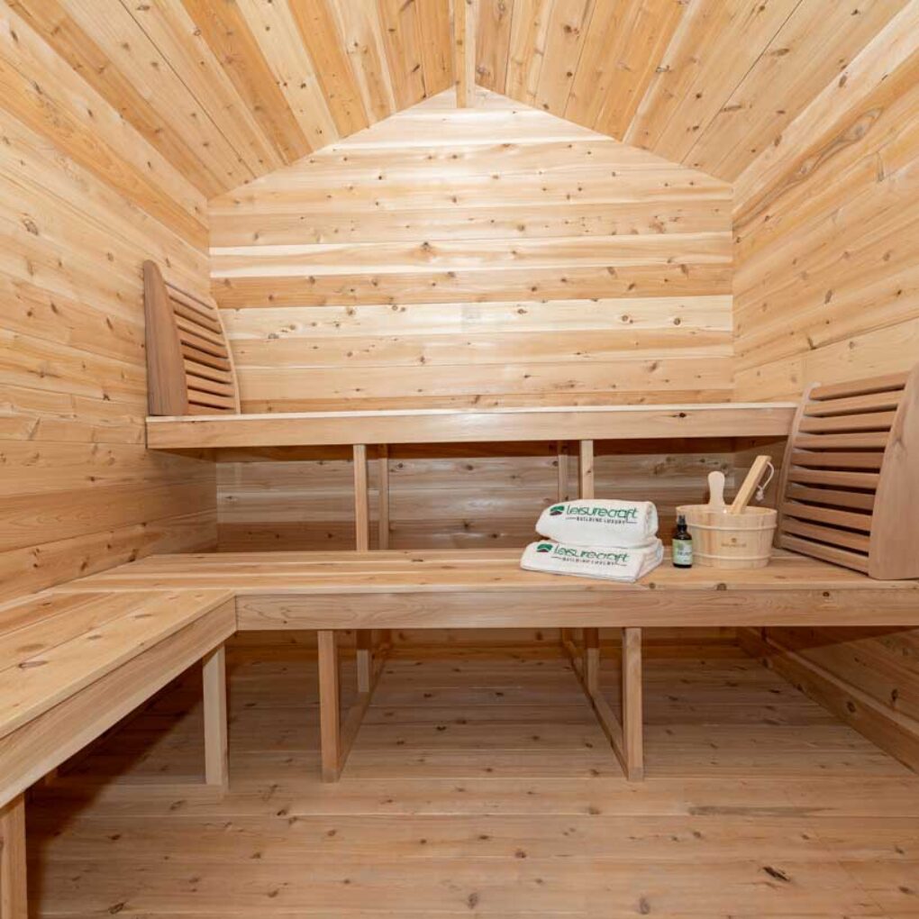 Interior view of the Georgian cedar sauna showing upper and lower benches with backrests, built for outdoor home wellness and heat therapy sessions.